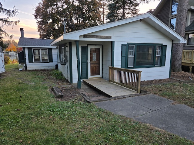 view of front of home featuring a deck and a lawn