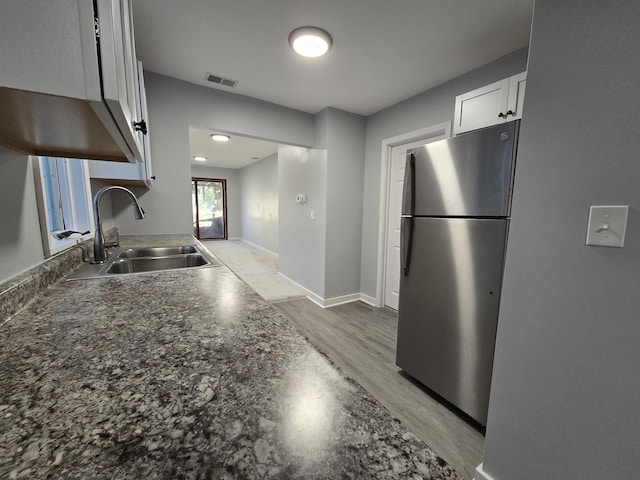 1007 River Rd, Mchenry, IL 60050 - kitchen with white cabinets, dark countertops, a sink, freestanding refrigerator, and visible vents