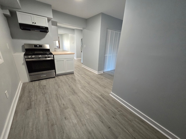 kitchen featuring light hardwood / wood-style flooring, white cabinetry, and stainless steel gas range