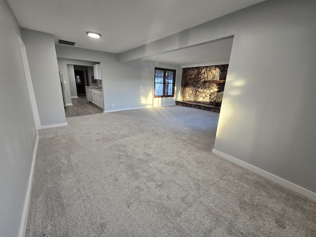1007 River Rd, Mchenry, IL 60050 - carpeted empty room featuring baseboards, visible vents, and a fireplace