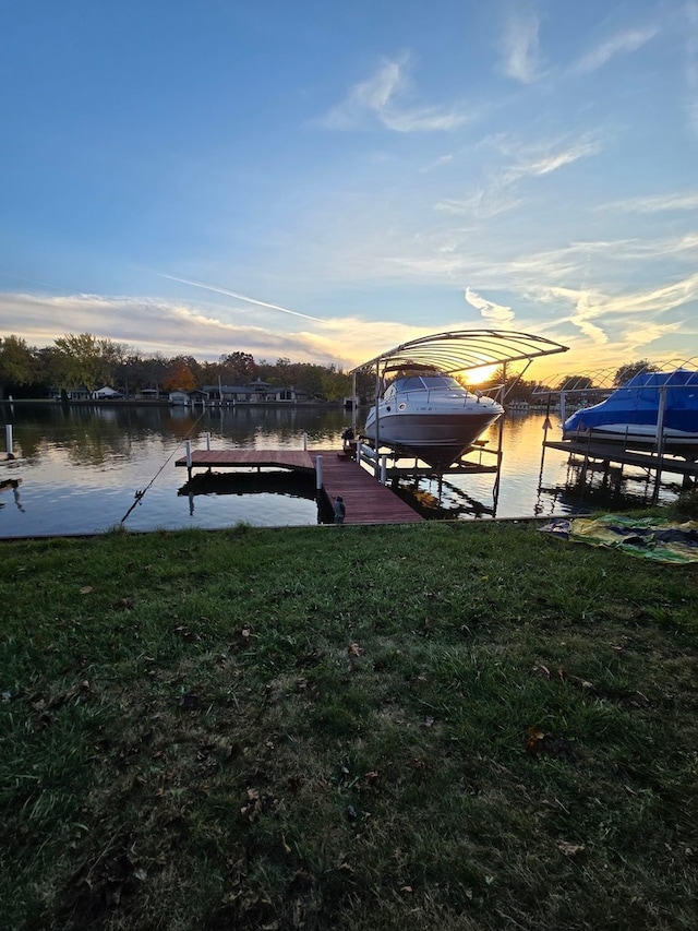 dock area with a water view and a lawn