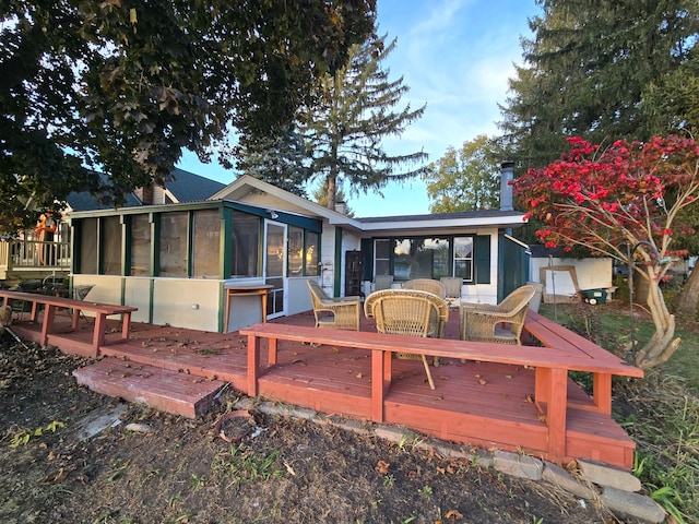 back of house featuring a wooden deck and a sunroom