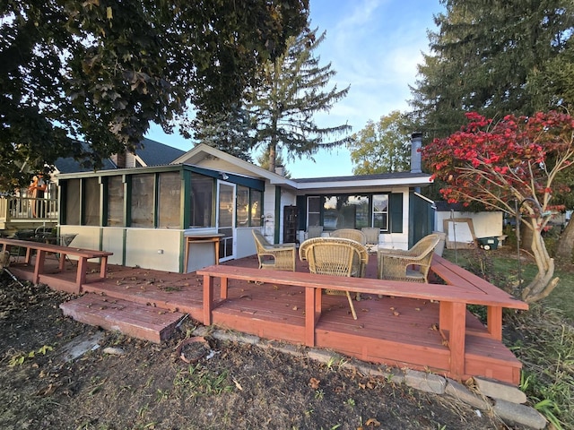 1007 River Rd, Mchenry, IL 60050 - rear view of house with a wooden deck, outdoor dining space, a sunroom, and a chimney