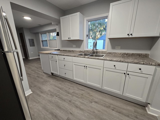 1007 River Rd, Mchenry, IL 60050 - kitchen featuring white cabinetry, a sink, baseboards, freestanding refrigerator, and light wood-style flooring