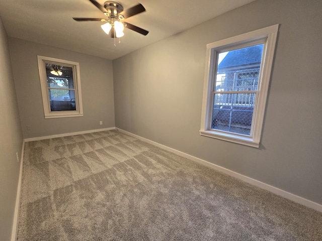 carpeted spare room featuring ceiling fan