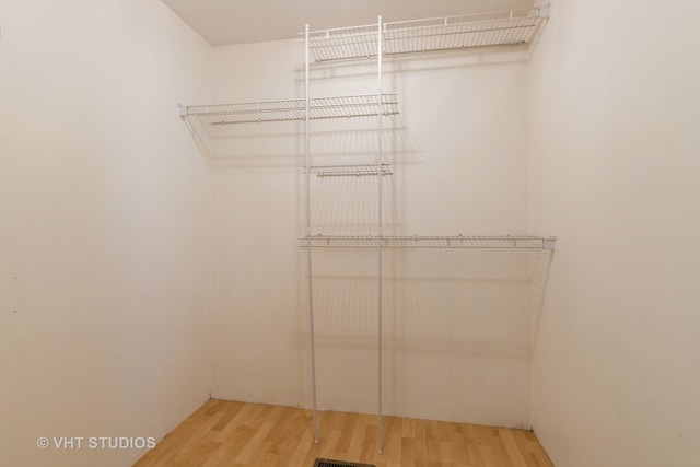 walk in closet with hardwood / wood-style flooring