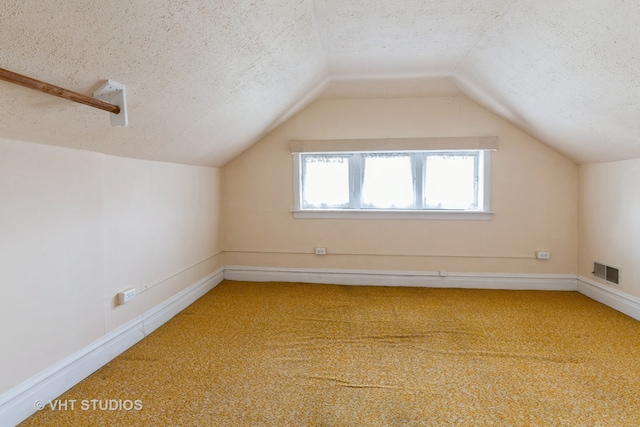 bonus room featuring a textured ceiling, carpet flooring, and vaulted ceiling