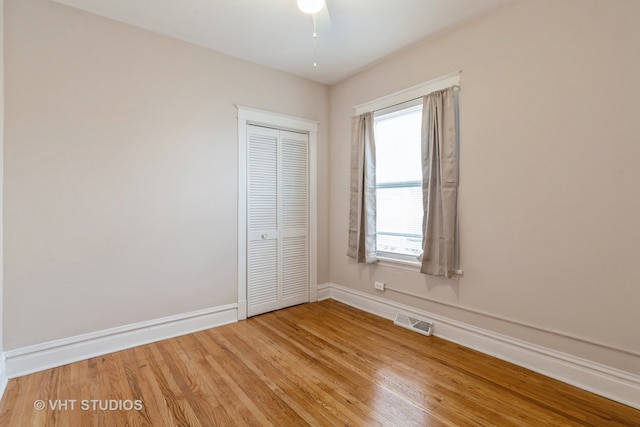 unfurnished bedroom featuring a closet, hardwood / wood-style flooring, and ceiling fan