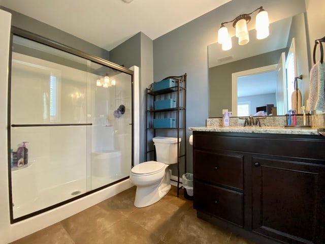 bathroom featuring walk in shower, vanity, and toilet