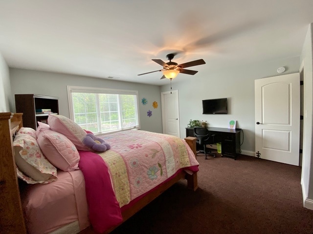 bedroom with ceiling fan and dark colored carpet