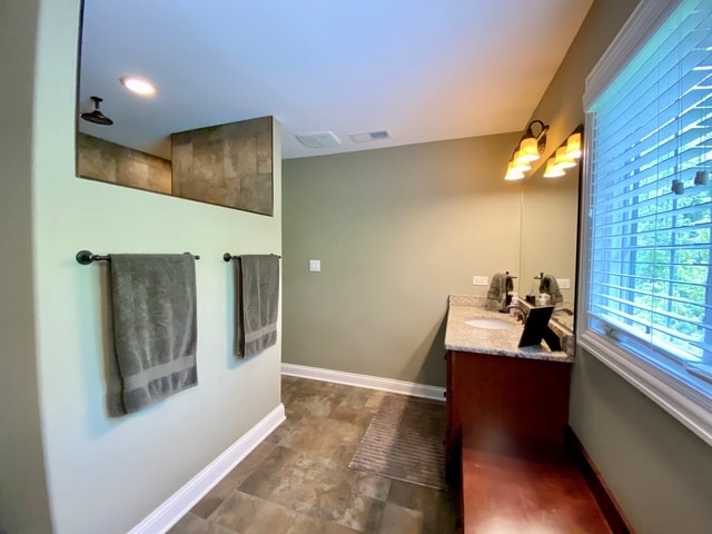 bathroom featuring a shower and vanity