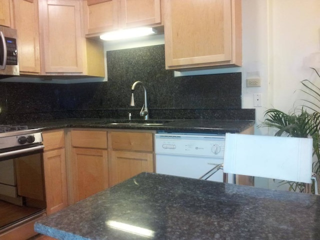 kitchen featuring tasteful backsplash, light brown cabinetry, dark stone counters, sink, and stainless steel appliances