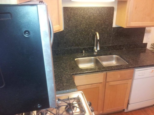 kitchen with light brown cabinetry, sink, white dishwasher, stainless steel fridge, and light hardwood / wood-style flooring