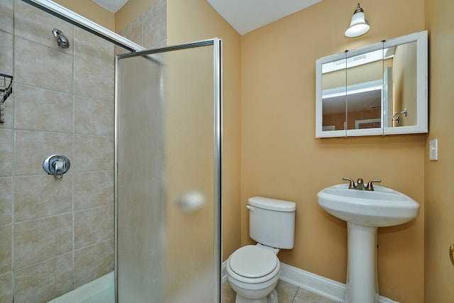 bathroom with toilet, an enclosed shower, sink, and tile patterned floors