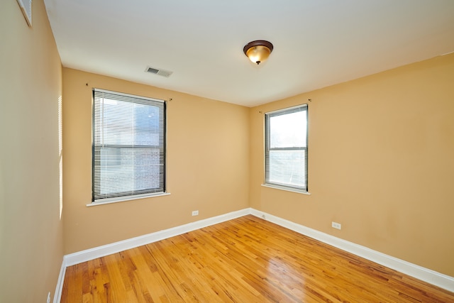 unfurnished room with hardwood / wood-style flooring and plenty of natural light