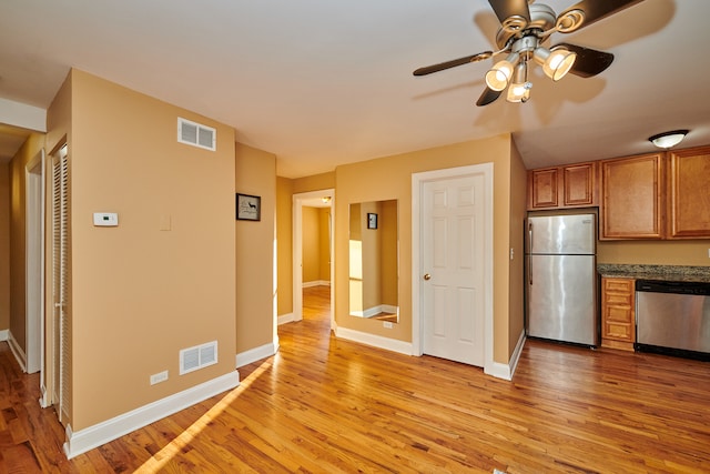 kitchen featuring appliances with stainless steel finishes, light hardwood / wood-style flooring, and ceiling fan