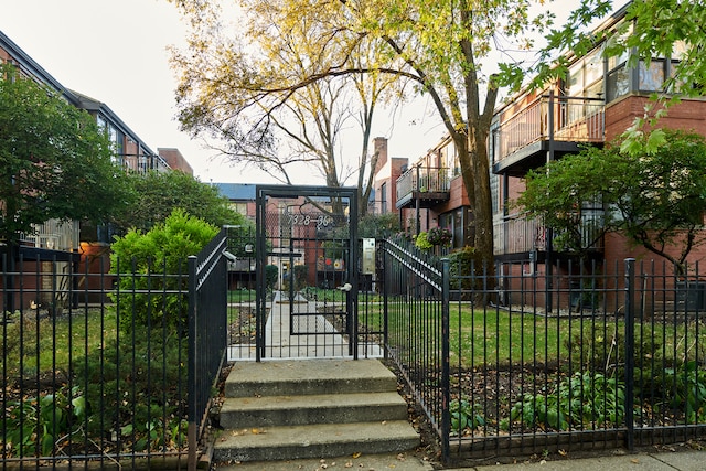 view of gate with a lawn