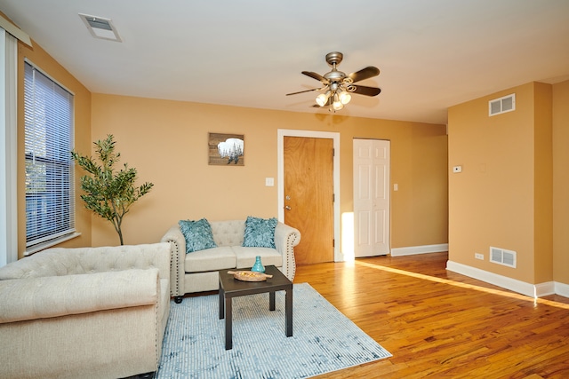 living room featuring wood-type flooring and ceiling fan