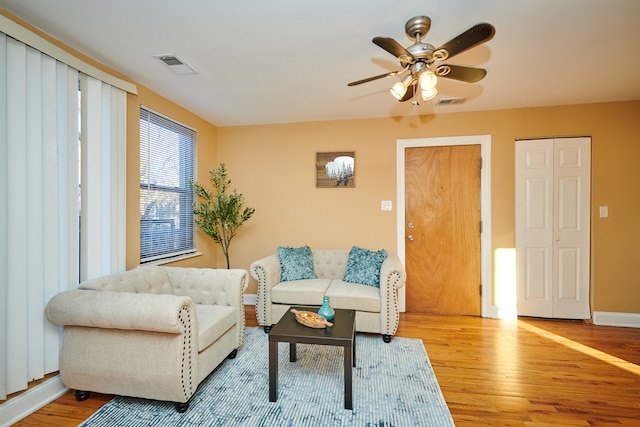 living room with hardwood / wood-style flooring and ceiling fan