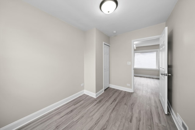 unfurnished bedroom with a closet and light hardwood / wood-style flooring