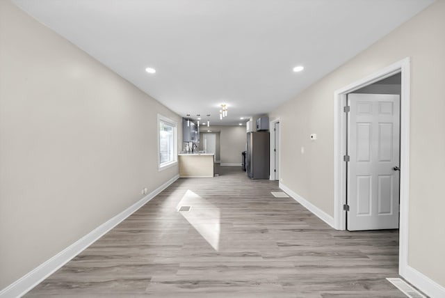 unfurnished living room featuring sink and light wood-type flooring