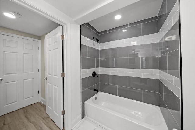 bathroom with tiled shower / bath combo and hardwood / wood-style flooring