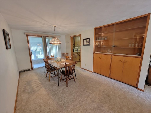 dining space with a notable chandelier and light colored carpet