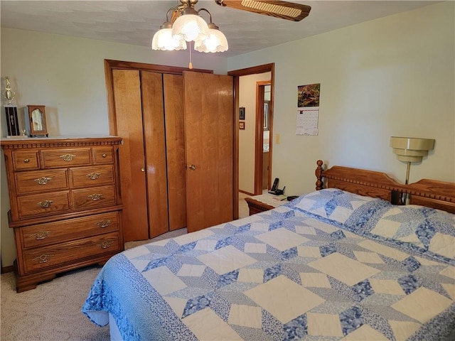 bedroom featuring light colored carpet, a closet, and ceiling fan