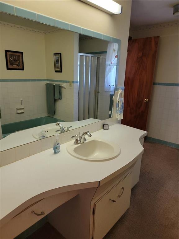 bathroom featuring vanity, tile walls, and a shower with door