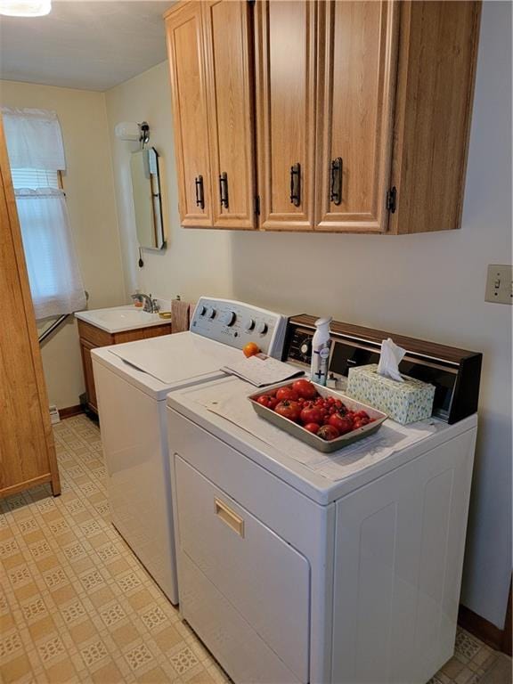 clothes washing area with cabinets, sink, and washing machine and clothes dryer