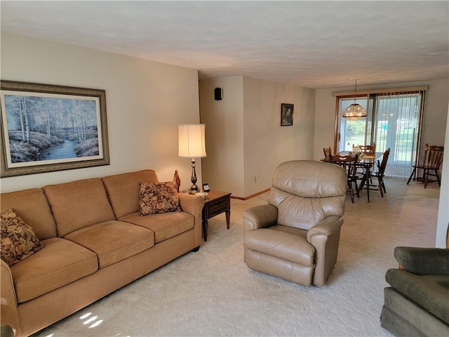 carpeted living room featuring an inviting chandelier