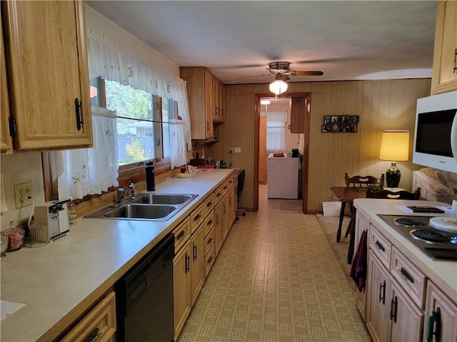 kitchen with dishwasher, washer / dryer, wooden walls, sink, and ceiling fan