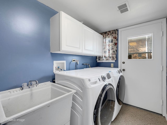 laundry area featuring light tile patterned floors, sink, separate washer and dryer, and cabinets