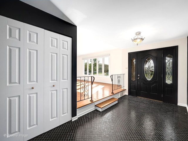 carpeted entrance foyer with lofted ceiling