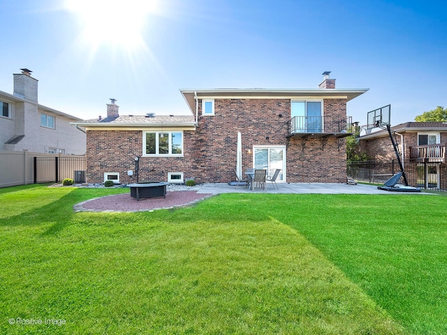 rear view of house featuring cooling unit, a patio area, a lawn, and a balcony