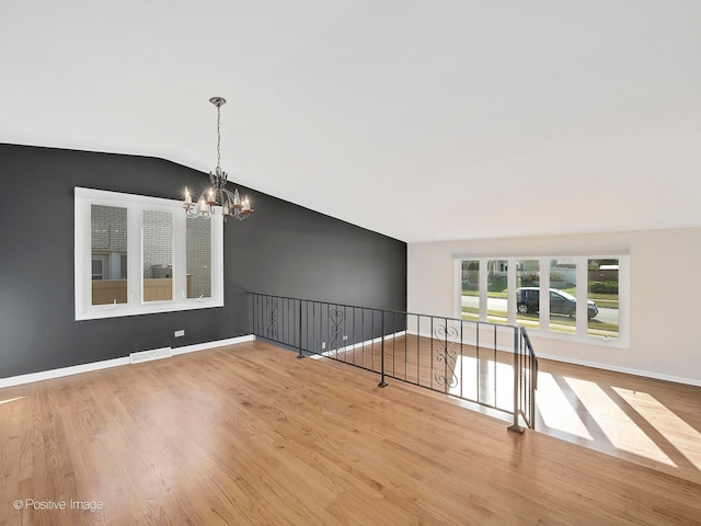 interior space featuring vaulted ceiling, light hardwood / wood-style flooring, and a notable chandelier