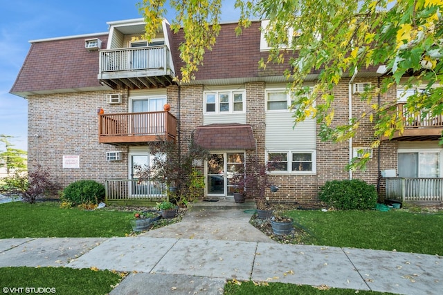 view of front of home featuring a balcony and a front lawn