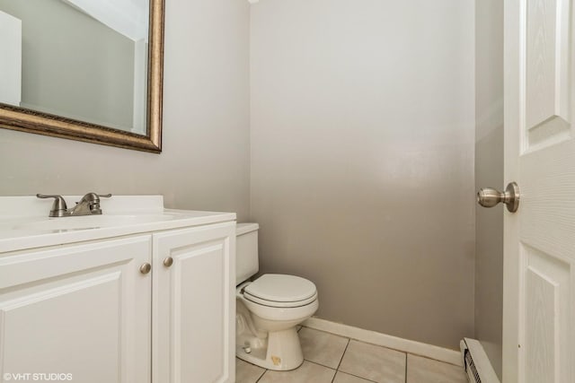 bathroom with tile patterned flooring, vanity, toilet, and a baseboard heating unit