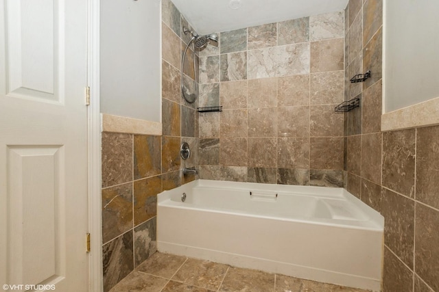 bathroom featuring tiled shower / bath and tile walls