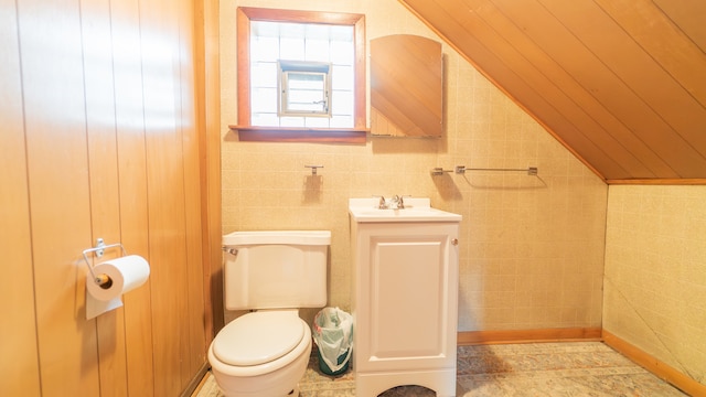 bathroom with lofted ceiling, vanity, and toilet