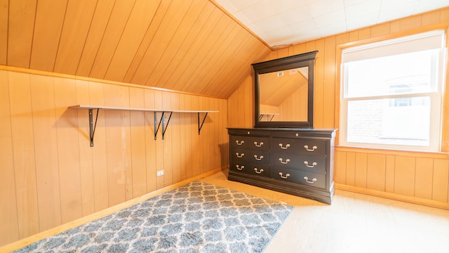 additional living space with lofted ceiling and wooden walls