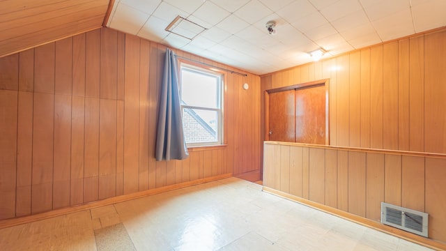11318 S S Ave J, Chicago, IL 60617 - unfurnished room featuring wooden walls, tile patterned floors, and lofted ceiling