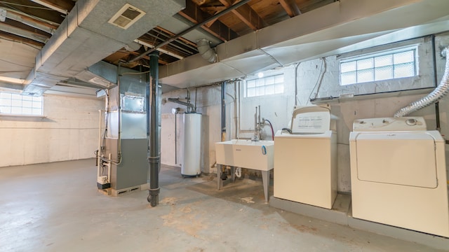 basement with heating unit, sink, independent washer and dryer, and gas water heater