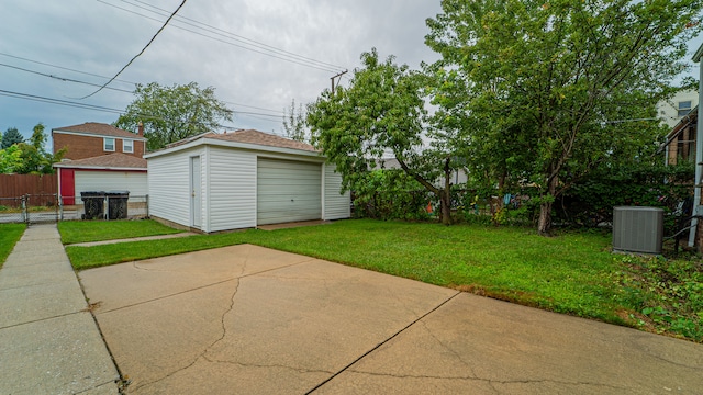 view of yard with a garage, cooling unit, and an outdoor structure