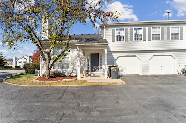 view of front of home with cooling unit and a garage