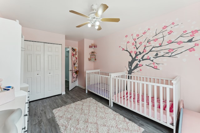 bedroom with dark hardwood / wood-style flooring, a crib, a closet, and ceiling fan