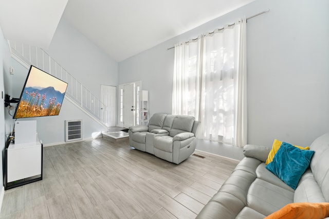 living room featuring high vaulted ceiling and light wood-type flooring