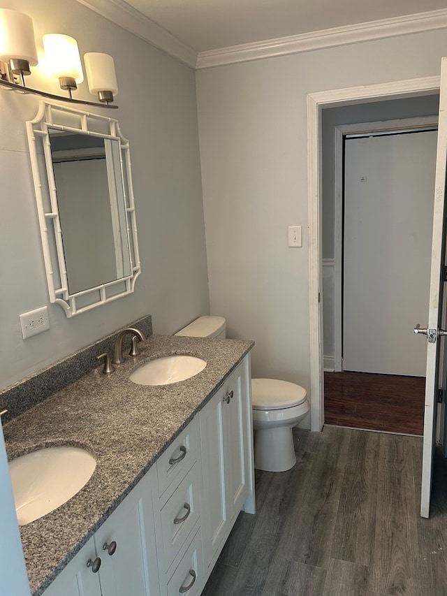 bathroom featuring toilet, crown molding, vanity, and wood-type flooring