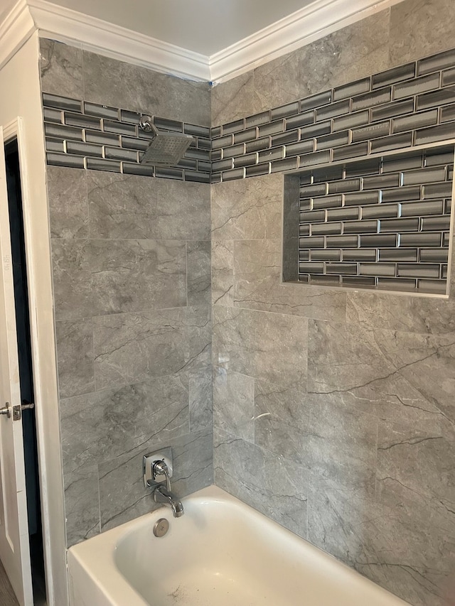 bathroom with crown molding and a bathtub