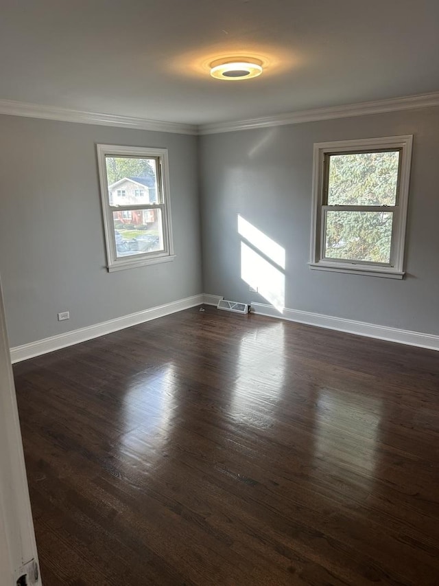 empty room featuring ornamental molding and dark hardwood / wood-style flooring